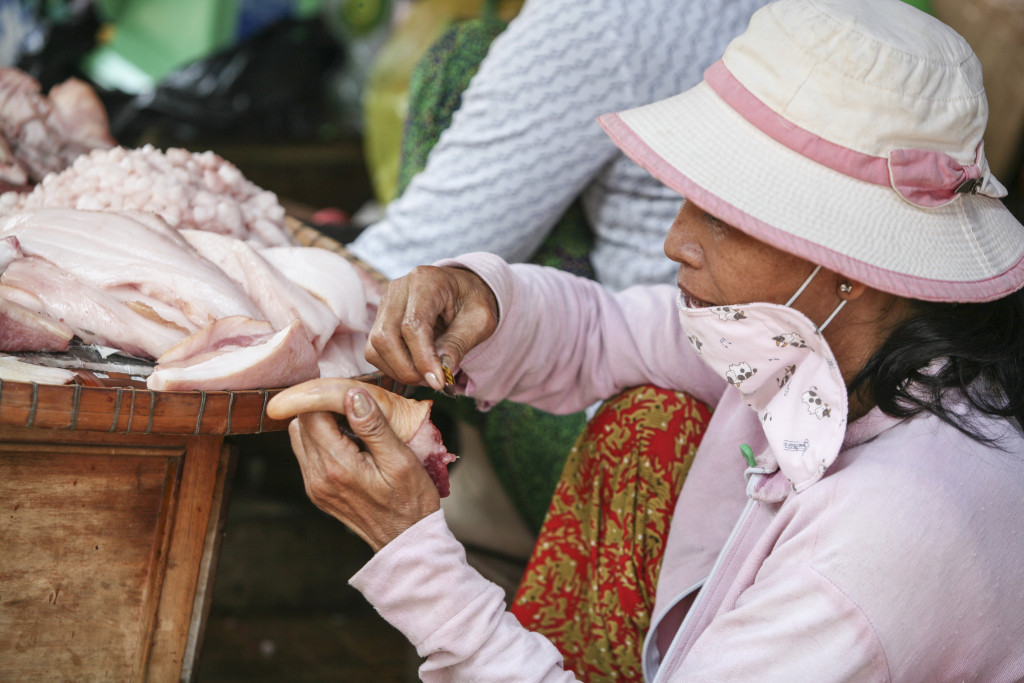 Vietnamská trhovkyně v Chau Doc s láskou holí prasečí ocásek. Asi aby se líp prodával. 